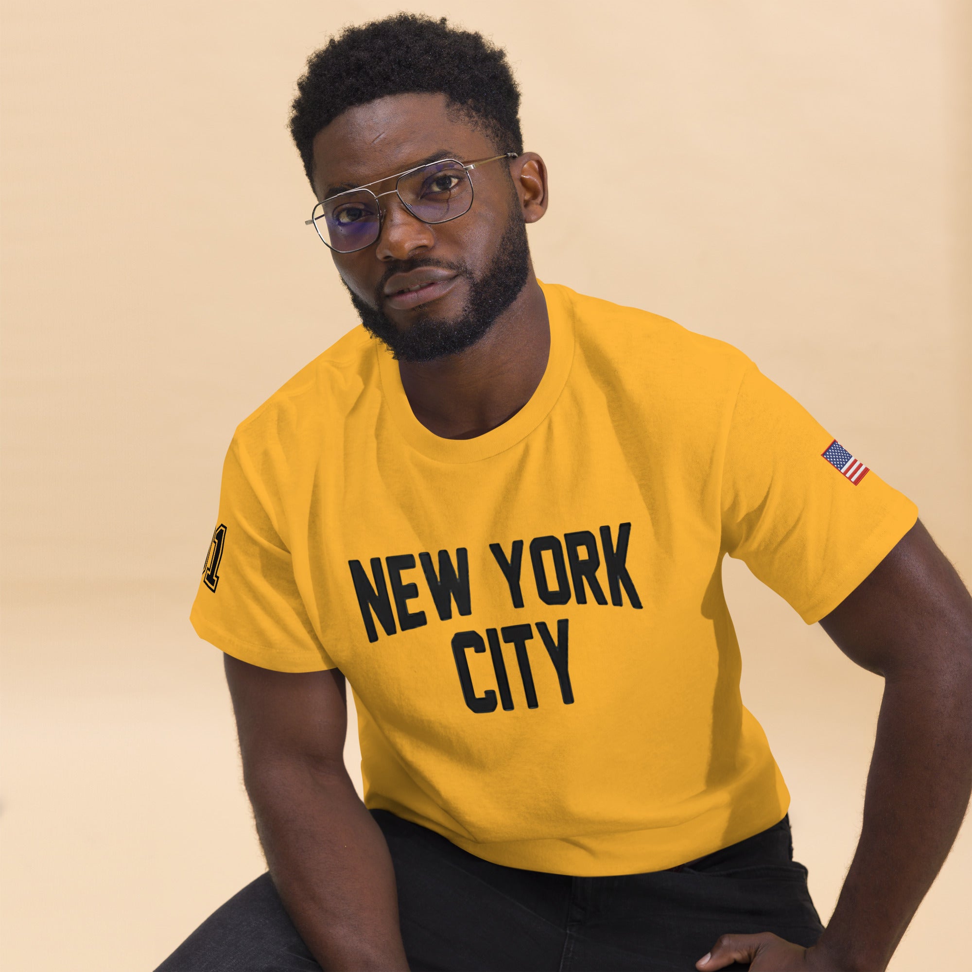 Man wearing a yellow 'New York City' t-shirt against a beige background
